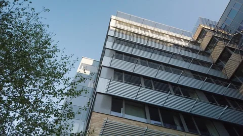 Rotating camera movement in front of modern office building windows reflecting Stock Footage 122212095