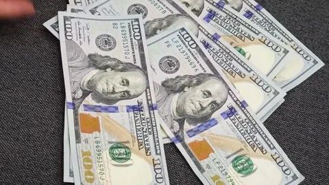 Rotating camera reveals 100-dollar bills appearing one by one in the frame Stock Footage 287034255
