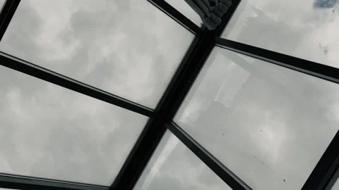 Rotating camera view through glass roof to cloudy sky Stock Footage 315188810