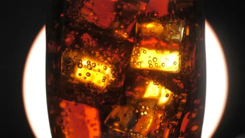 Rotating carbonated drink with bubbles in the glass. Ice cubes in a glass. Stock Footage 129802174