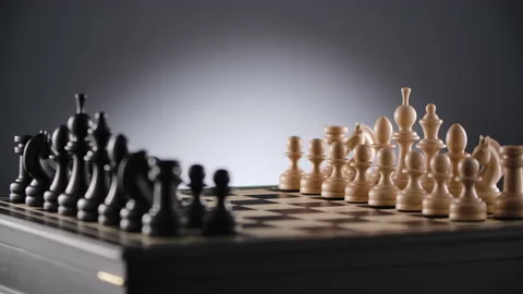 Rotating chessboard with lines of white and black wooden chess figures Stock Footage 166846801