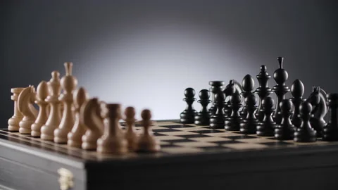 Rotating chessboard with lines of white and black wooden chess figures Stock Footage 166847007