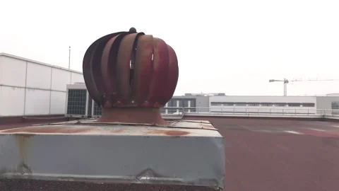 Rotating Chimney Ventilator on Rooftop with Urban Background. Spinning Turbine Stock Footage 303868418