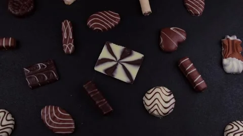 Rotating chocolate chip cookies of different shapes and chocolates on a black Stock Footage 167563915