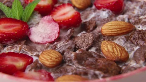 Rotating of chocolate cornflakes with milk and strawberry. Side view, close up. Stock Footage 135042838