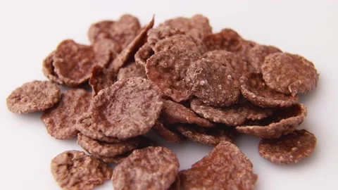 Rotating of chocolate cornflakes on white background. Side view, close up. Stock Footage 135042689