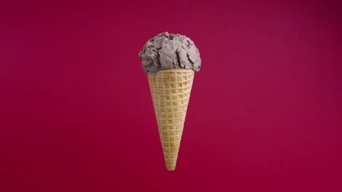 Rotating chocolate ice cream ball in waffle cone on red background. Soft cream Stock Footage 168664841
