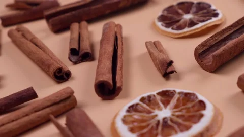 Rotating cinnamon sticks and dried lemon slices on a beige background Stock Footage 212320137
