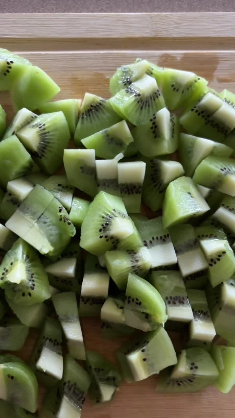 Rotating Close-Up of Fresh Sliced Kiwi Fruit on Wooden Cutting Board Stock Footage 337848934