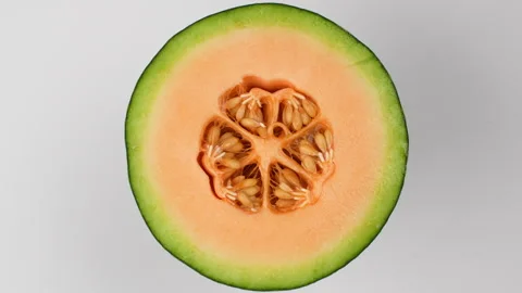 Rotating Close Up Half Green Netted Melon With Orange Flesh And Seeds 4K Stock-Footage 323017623