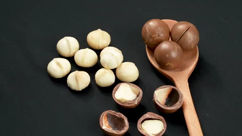 Rotating Close-up of Macadamia Nuts and Wooden Spoon. Stockbeeldmateriaal 332830680