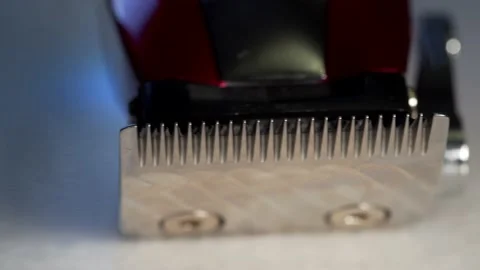 A rotating close up macro clip of barbers red professional quality hair clipp Vídeos de archivo 149776480
