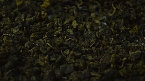 Rotating close-up of premium green Oolong tea leaves on a turntable background Vidéo 346520584
