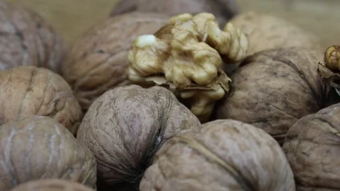 Rotating close-up of walnuts, both in shells and shelled, on display. Stock Footage 299093760