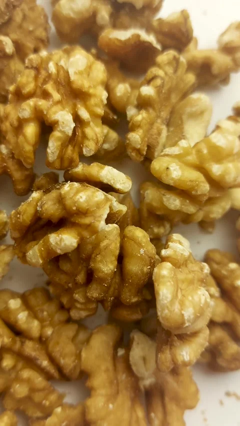 Rotating close-up of whole shelled walnuts on a white turntable background Vidéo 346520607