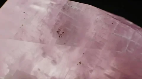 Rotating Closeup of Rough Pink Stone on Black Background Stock Footage 313324212