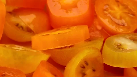 Rotating closeup view of fresh yellow cherry tomato slices creating a vibra.. Stock Footage 321832835