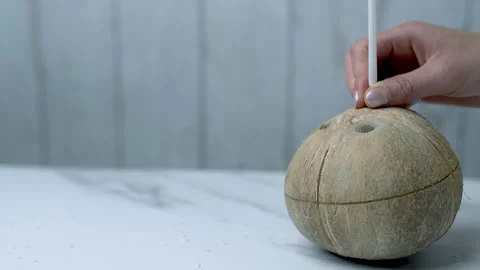 Rotating a Coconut and inserting a straw in a Coconut for drinking in 4K Stock Footage 138252444