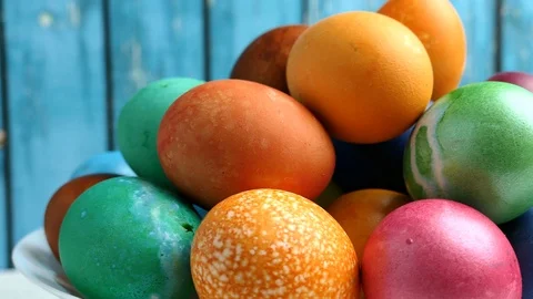 Rotating Of Colorful Easter Eggs Lying On White Plate On A Blue Wooden Backgroun Vídeos de archivo 126575158