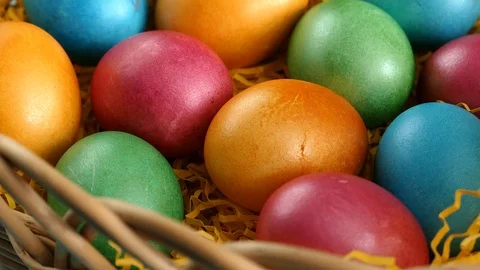 Rotating Of Colorful Easter Eggs Lying On Straw In A Basket On A Blue Wooden Bac Stock Footage 126589643
