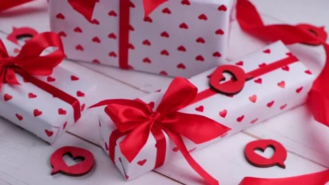 Rotating composition with gift boxes wrapped in paper with hearts and red bows Stock Footage 167495282