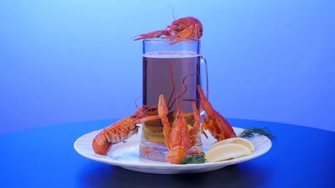 Rotating crayfish on a white dish with lemon on a blue background. Stock Footage 125931008