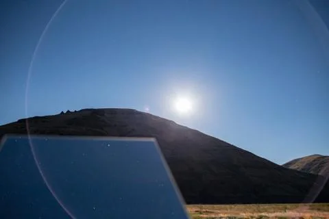 Rotating creative mirror in the desert at night blue moonlit sky Stock Photos
