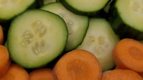 Rotating cucumber pieces and sliced carrot. Stock Footage 290870462