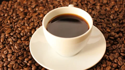 Rotating cup of coffee with coffee beans and ground coffee around Stock Footage 35208798