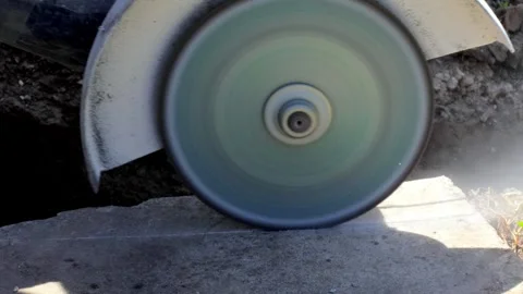 A rotating cutting disc on an angle grinder cuts concrete close-up 4k video Stock Footage 277497351