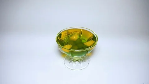 Rotating dessert gelatin multicolour on white background. Slow motion Stock Footage 82957050