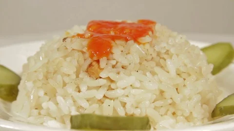 Rotating dish of rice with marinaded cucumbers Stock Footage 70069819