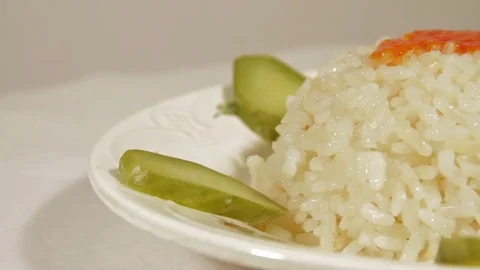 Rotating dish of rice with marinaded cucumbers Stock Footage 70070140