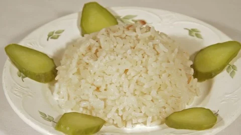 Rotating dish of rice with marinaded cucumbers Stock Footage 70070451