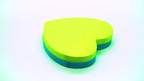 Rotating display of a heart shaped sticky note stack on a clean white backg.. Stock Footage 342020019