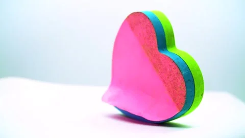 Rotating display of a heart shaped sticky note stack on a clean white backg.. Stock Footage 342020091