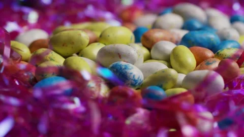Rotating display of speckled chocolate easter eggs in tinsel Stock Footage 327829406