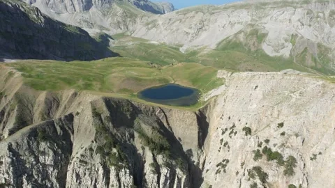 Rotating Drone Captures Mountain Lake on Cliff in Greece Stock Footage 303399233