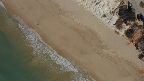 Rotating Drone View Of Two People Walking On The Sandy Beach Stock Footage 128833988
