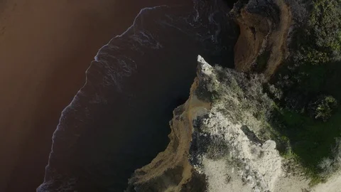 Rotating Drone View Of The Waves Comes To Shore From Cliff Stock Footage 128837221