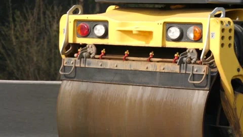 Rotating drum of roller-compactor compressing asphalt Stock Footage 158040925