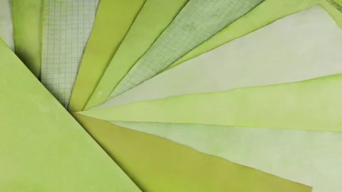 Rotating fan of handmade paper sheets in olive and pale lime shades.  Stock-Footage 330253960