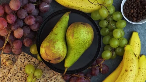 Rotating flatlay of pears with grapes bananas coffee beans and crackers Stock Footage 320029373