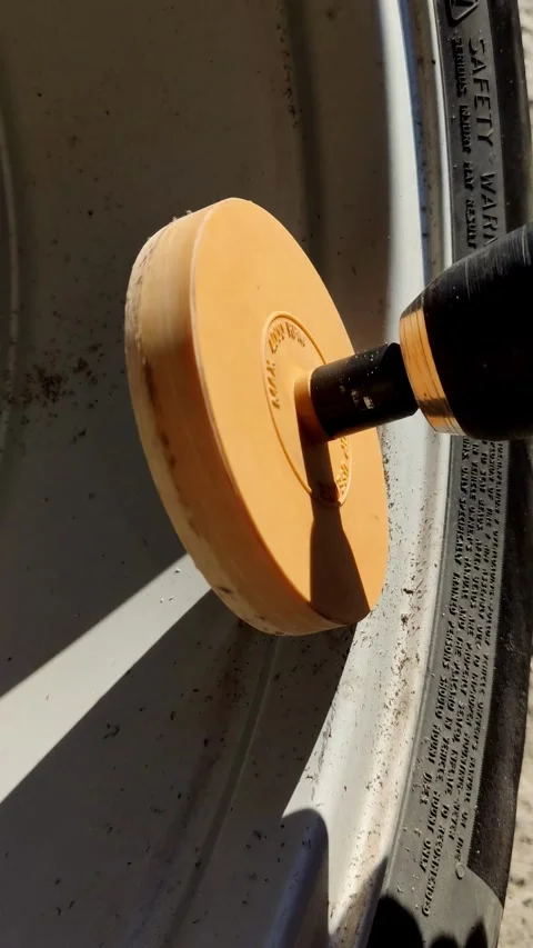 Rotating foam polishing pad buffing a car body at night Stock Footage 333702054