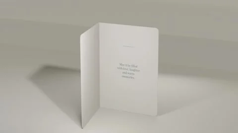 Rotating folded card gold-foil house embossed title, opening on tabletop to Stock Footage 339721886