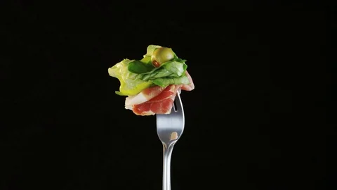 Rotating Fork With Ham and Lettuce on Black Background Stock Footage 70542360