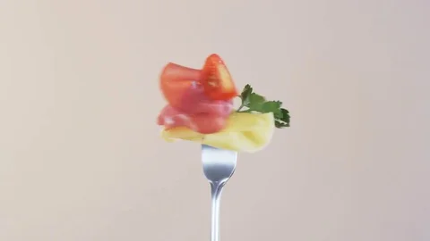 Rotating Fork With Ham, Cheese and Cocktail Tomato on Almond Background Stock Footage 70538562