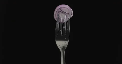 Rotating fork with onion on black background Stock Footage 144329055