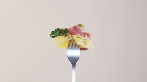 Rotating Fork With Salami and Cheese on Almond Background Stock Footage 70538645