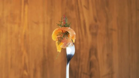 Rotating Fork With Salmon and Chili Pepper on Wooden Background Stock Footage 70540523